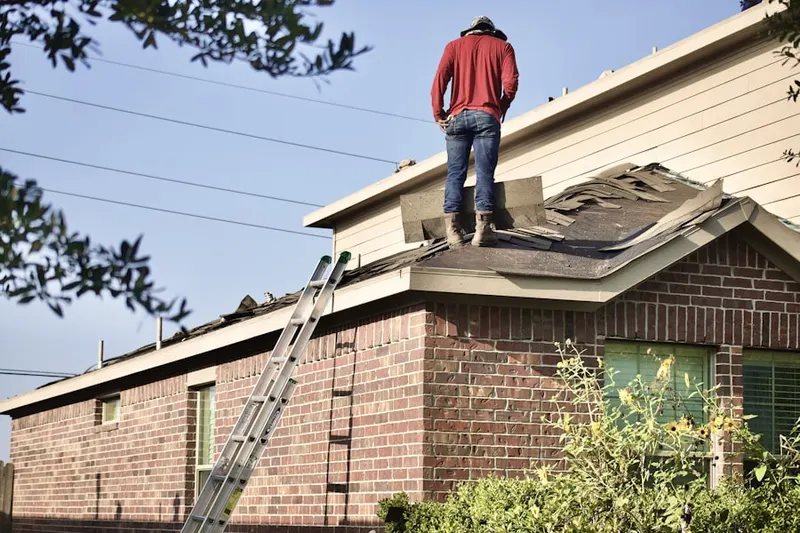 Professional roofer working on a residential roof in Village Cottages